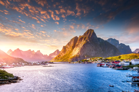 Fjord und Berge im Sonnenuntergang, kleine Hafenstadt rechts 